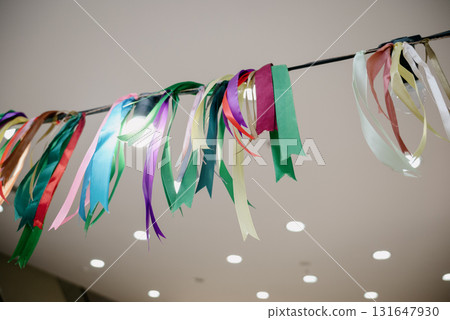 Multicolored ribbons and a garland of light bulbs under the ceiling 131647930