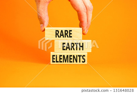 Rare earth elements symbol. Concept words Rare earth elements on beautiful wooden block. Businessman's hand. Beautiful orange background. Business and rare earth elements concept. Copy space. Rare earth elements symbol. Concept words Rare earth elements on beautiful wooden block. Businessman's hand. Beautiful orange background. Business and rare earth elements concept. Copy space. 131648028