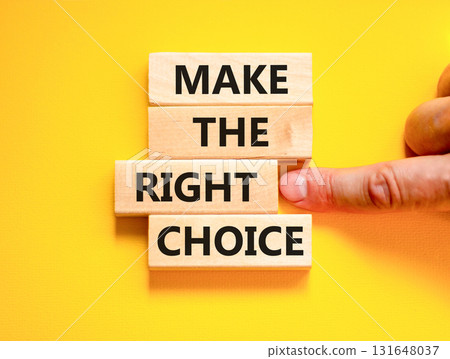 Make the right choice symbol. Concept words phrase Make the right choice on beautiful wooden blocks. Beautiful yellow background. Businessman's hand. Business Make the right choice concept. Copy space 131648037