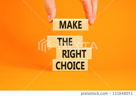 Make the right choice symbol. Concept words phrase Make the right choice on beautiful wooden blocks. Beautiful orange background. Businessman's hand. Business Make the right choice concept. Copy space 131648051