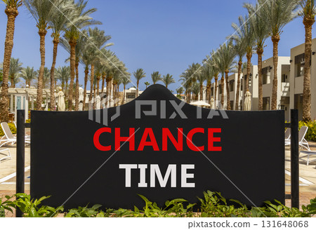 Chance time symbol. Concept word Chance time on beautiful black road sign. Beautiful palm trees and blue sky background. Business chance time concept. Copy space. Chance time symbol. Concept word Chance time on beautiful black road sign. Beautiful palm trees and blue sky background. Business chance time concept. Copy space. 131648068