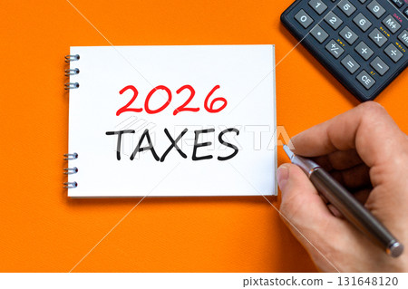2026 taxes new year symbol. Concept words 2026 taxes on beautiful white note. Black calculator. Beautiful orange background. Businessman's hand. Business and 2026 taxes new year concept. Copy space. 131648120