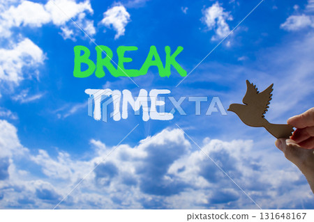 Break time symbol. Concept word Break time on beautiful blue sky. Businessman's hand with wooden bird. Beautiful blue sky and cloud background. Business break time concept. Copy space. Break time symbol. Concept word Break time on beautiful blue sky. Businessman's hand with wooden bird. Beautiful blue sky and cloud background. Business break time concept. Copy space. 131648167