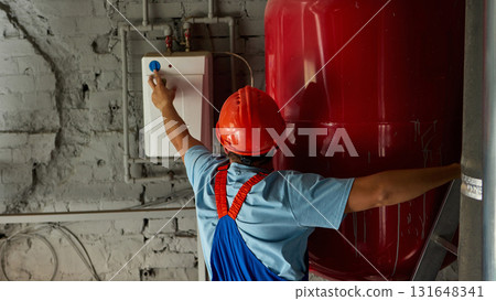 Engineer testing control panel on industrial heating system 131648341