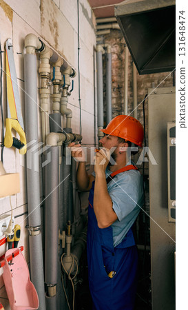 Technician checking heating pipes during maintenance work Technician checking heating pipes during maintenance work 131648474