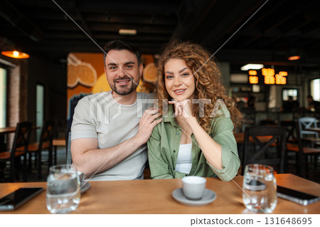 Young couple smiling and posing in a restaurant Young couple smiling and posing in a restaurant 131648695
