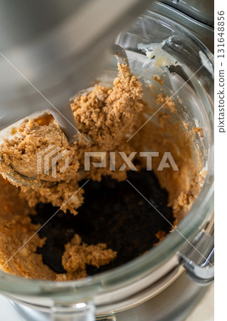 Adding the molasses and egg mixture into the creamed butter and sugar in preparation for Chocolate Gingerbread Cookie Dough. This dark, rich molasses will give the dough a deep flavor and color. 131648856