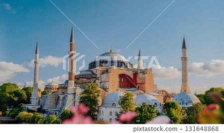 A view of hagia sophia with its minarets and domes under a clear blue sky with some trees and flowers 131648868