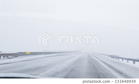 POV-Electric vehicle is captured deftly navigating the I-70 highway during a winter storm in Western Colorado. 131648939