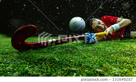 Female hockey player sliding on grass in emotional dive reaching ball Female hockey player sliding on grass in emotional dive reaching ball 131649287