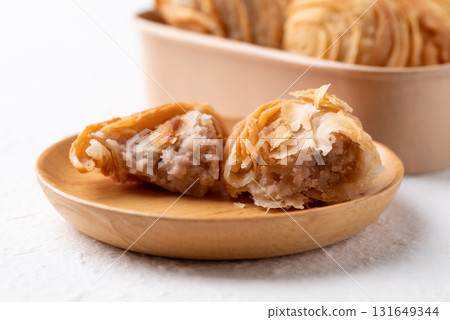 Curry puff stuffed with sweet taro on wooden plate, Thai snack food style Curry puff stuffed with sweet taro on wooden plate, Thai snack food style 131649344