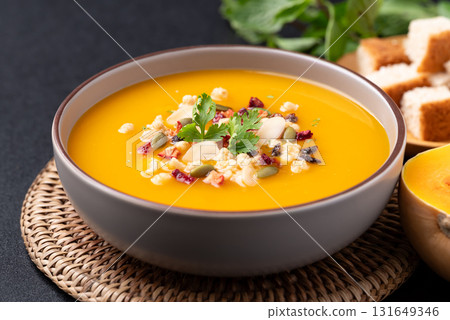 Butternut squash pumpkin soup with granola in a bowl, Homemade food in autumn season Butternut squash pumpkin soup with granola in a bowl, Homemade food in autumn season 131649346