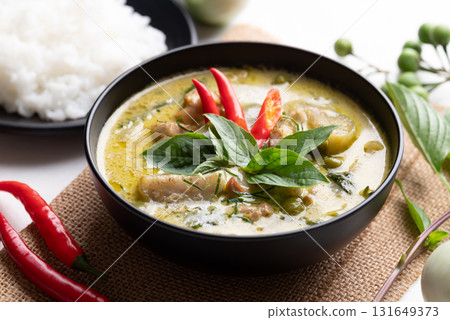 Thai green curry chicken in black bowl with rice and ingredients 131649373