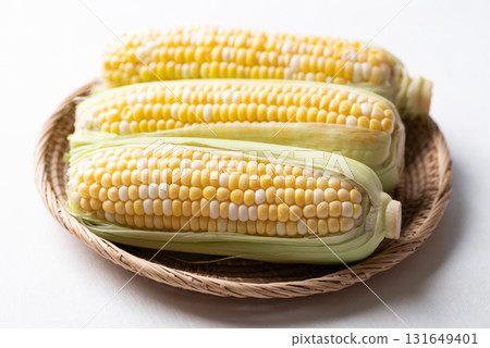 Fresh sweetcorn (bicolor) in basket on white background 131649401