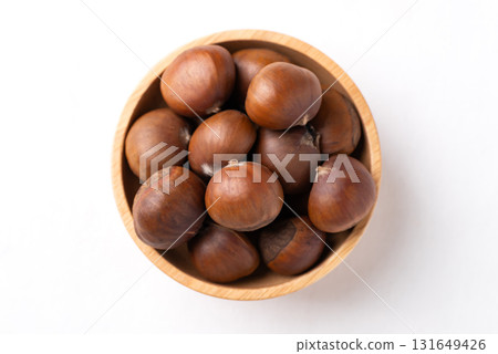 Top view of roasted chestnuts in wooden bowl on white background, Japanese chestnuts Top view of roasted chestnuts in wooden bowl on white background, Japanese chestnuts 131649426