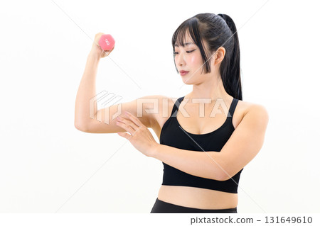 A cool woman working out, holding dumbbells and building biceps, muscle training, white background, cropped 131649610