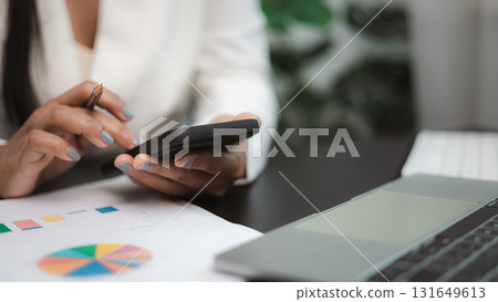 Businesswoman using smartphone for online communication and financial work at modern office 131649613