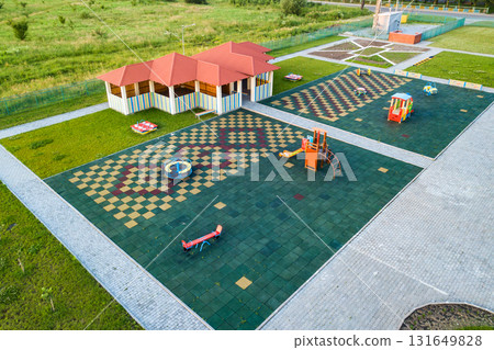 Aerial view of new alcove in kindergarten play yard with red tiled roof for outdoor children activities. 131649828