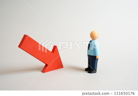An office worker evaluates the red arrow of decline. A drop in income or performance. Economic problems. Facing layoffs. Concept for crisis management, unemployment, and finance. 131650176