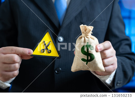 A businessman is forced to cut his budget. Budget sequestration. Saving and cutting costs. Financial crisis, economic slowdown, austerity measures, and expense management. 131650233