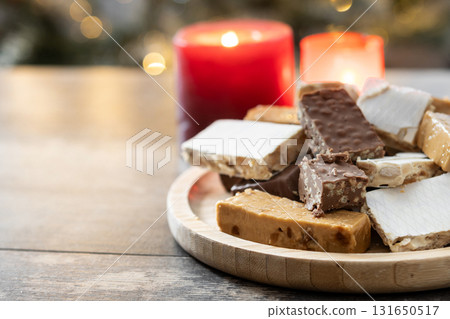 Assorted traditional Christmas nougat on wooden plate 131650517