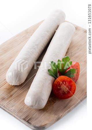 Raw Bratwurst sausages with cherry tomatoes and parsley 131651078