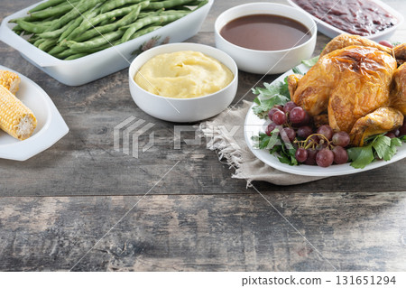 Thanksgiving roasted turkey with mashed potatoes, cranberry sauce and green beans on rustic wooden table Thanksgiving roasted turkey with mashed potatoes, cranberry sauce and green beans on rustic wooden table 131651294