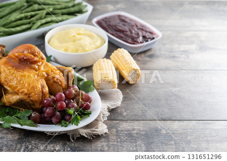 Thanksgiving roasted turkey with mashed potatoes, cranberry sauce and green beans on rustic wooden table Thanksgiving roasted turkey with mashed potatoes, cranberry sauce and green beans on rustic wooden table 131651296