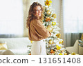 Woman Posing by a Festive Christmas Tree 131651408