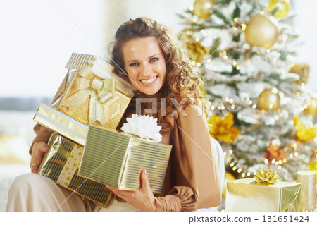 Smiling Woman with Gold Green Christmas Gifts 131651424