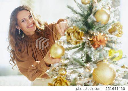 Woman\'s Joyful Close-up Decorating Christmas Tree 131651430