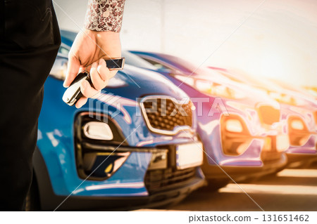 transportation and ownership concept - customer and salesman with car key outside 131651462