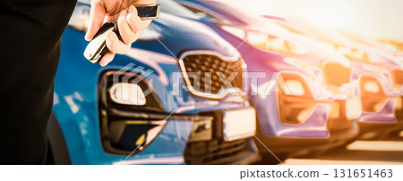 transportation and ownership concept - customer and salesman with car key outside 131651463