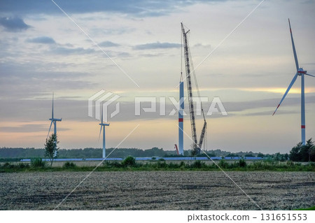 under construction Wind tower turbine power plant at sunset under construction Wind tower turbine power plant at sunset 131651553