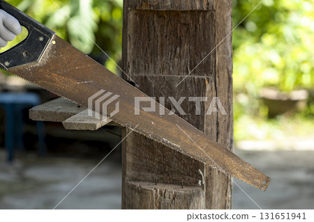 Hand saw cutting wood outdoors, rustic scene shows texture and craftsmanship 131651941
