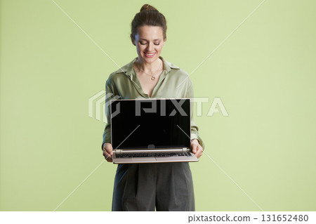 Woman presents blank laptop screen Woman presents blank laptop screen 131652480