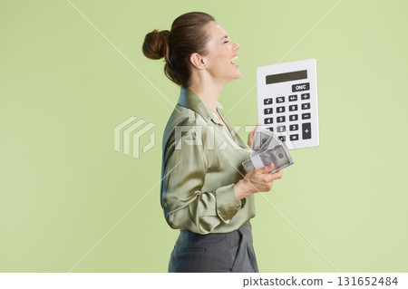Laughing woman with cash & calculator: Financial joy. 131652484