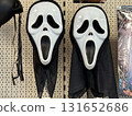 White plastic masks with wide open mouths and black drapes hanging on retail shelf. Horror disguise, halloween costume, spooky entertainment, cultural tradition and eerie movie character. 131652686