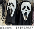 White plastic masks with wide open mouths and black drapes hanging on retail shelf. Horror disguise, halloween costume, spooky entertainment, cultural tradition and eerie movie character. 131652687