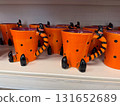 Orange ceramic mugs with witch legs and striped handles on store shelf. Halloween decoration, seasonal festivity, tradition, holiday merchandise, quirky design and spooky culture. 131652689