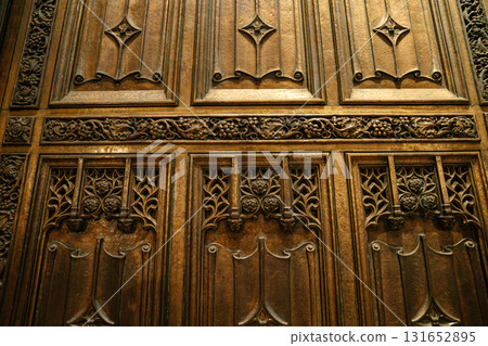 The photo captures a close-up of an ornate bronze door at St. Patrick's Cathedral in New York City. Intricate floral and vine carvings highlight the craftsmanship and Gothic style of this historic 131652895