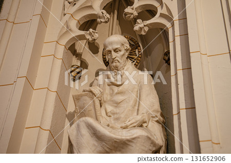 The image shows a close-up of Saint Gregory of Nazianzus carved in marble, seated with a book in a Gothic cathedral niche. The sculpture features a halo and is surrounded by detailed stonework and 131652906