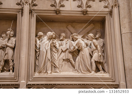 A detailed stone relief shows Jesus carrying the cross and meeting His sorrowful mother. The scene captures emotion, devotion, and intricate craftsmanship in every figure. 131652933