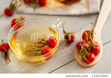 Medicinal rosehip tea in a cup on a wooden table 131653007