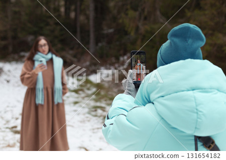 Winter bloggers recording video and capturing memories in a snowy forest setting Winter bloggers recording video and capturing memories in a snowy forest setting 131654182