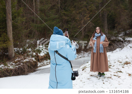 Winter bloggers capturing moments in a snowy forest landscape Winter bloggers capturing moments in a snowy forest landscape 131654186