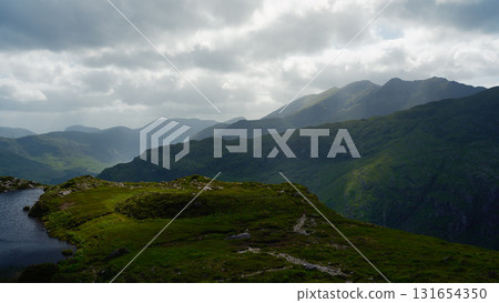 Dramatic, rocky mountain peak overlooking a verdant valley. A stunning natural scene. Dramatic, rocky mountain peak overlooking a verdant valley. A stunning natural scene. 131654350