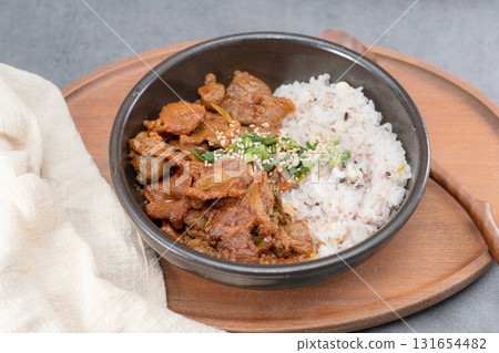 Jeyukdeopbap, Korean Food Spicy Stir-fried Pork with Rice in Black Bowl  131654482