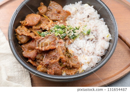 Jeyukdeopbap, Korean Food Spicy Stir-fried Pork with Rice in Black Bowl Jeyukdeopbap, Korean Food Spicy Stir-fried Pork with Rice in Black Bowl 131654487