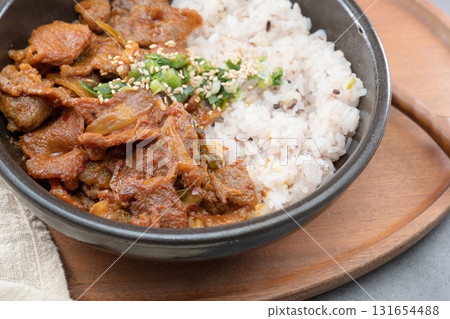 Jeyukdeopbap, Korean Food Spicy Stir-fried Pork with Rice in Black Bowl  131654488
